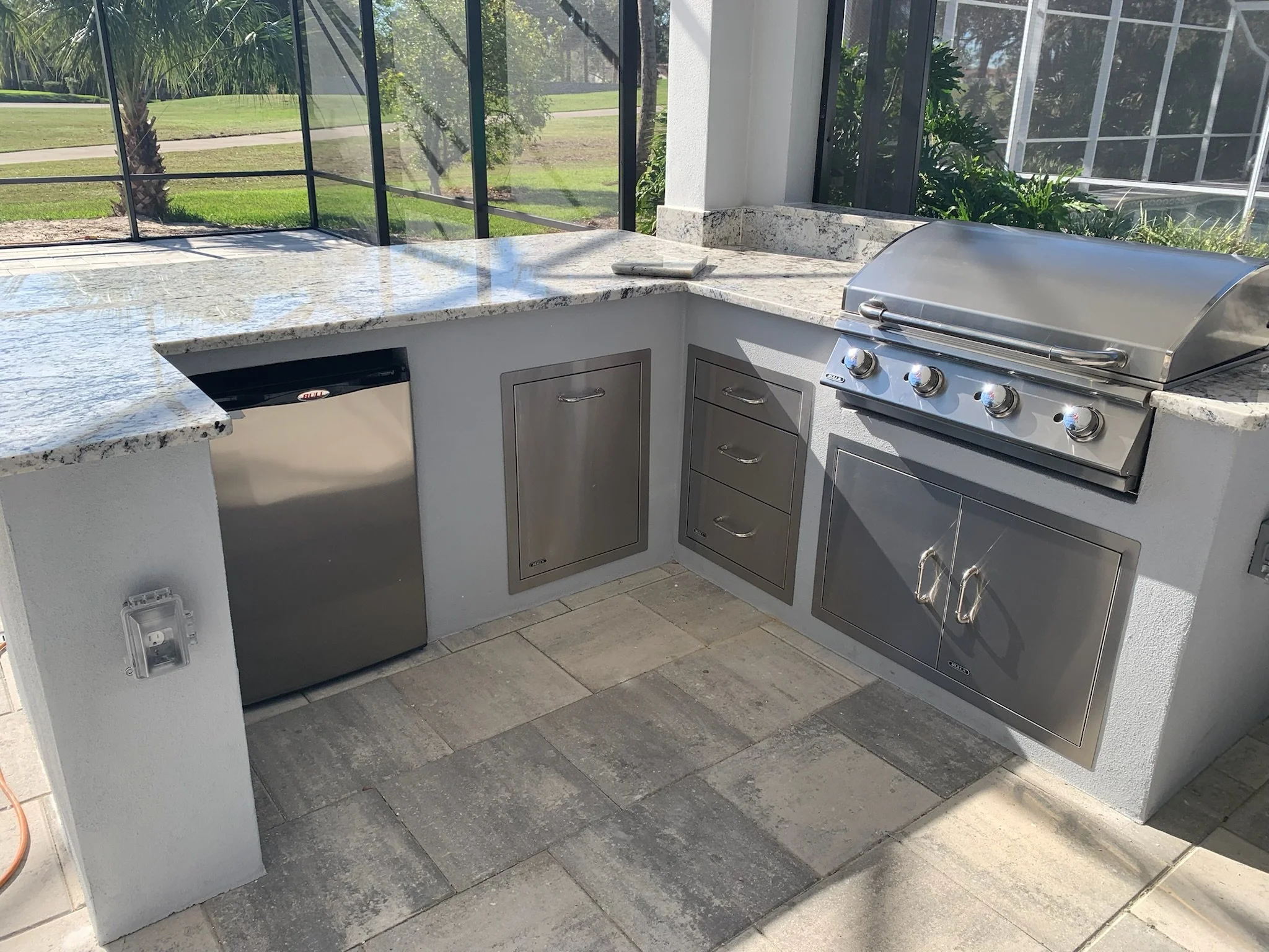 Outdoor kitchen with a granite countertop and stainless steel grill